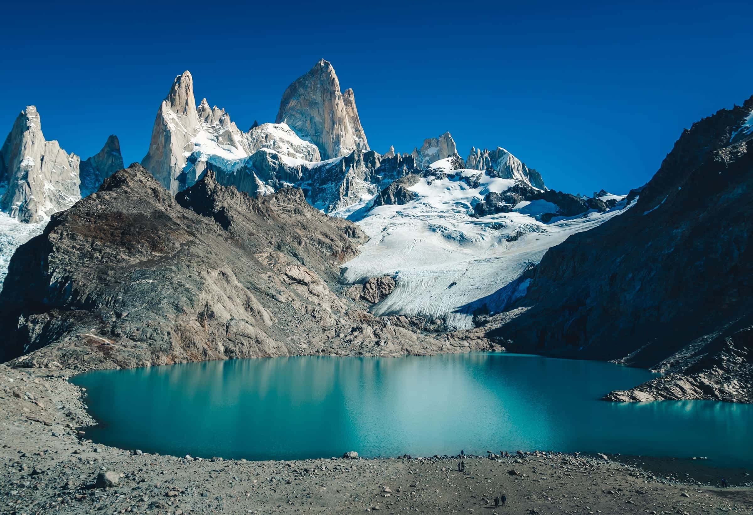 The granite spires of Fitz Roy and a glacier above a turquoise alpine lake