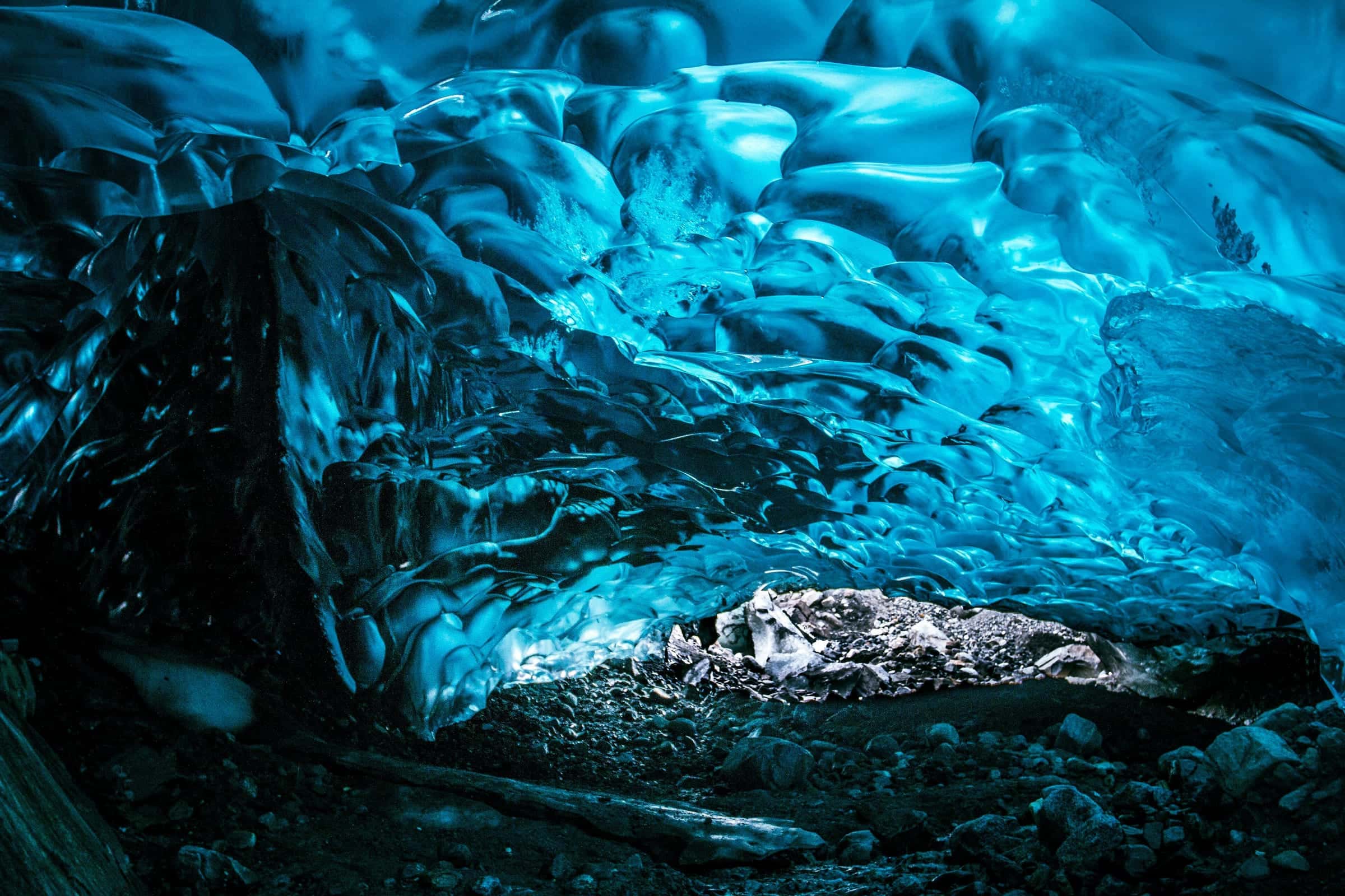 Inside a glacier ice cave with electric-blue scalloped walls